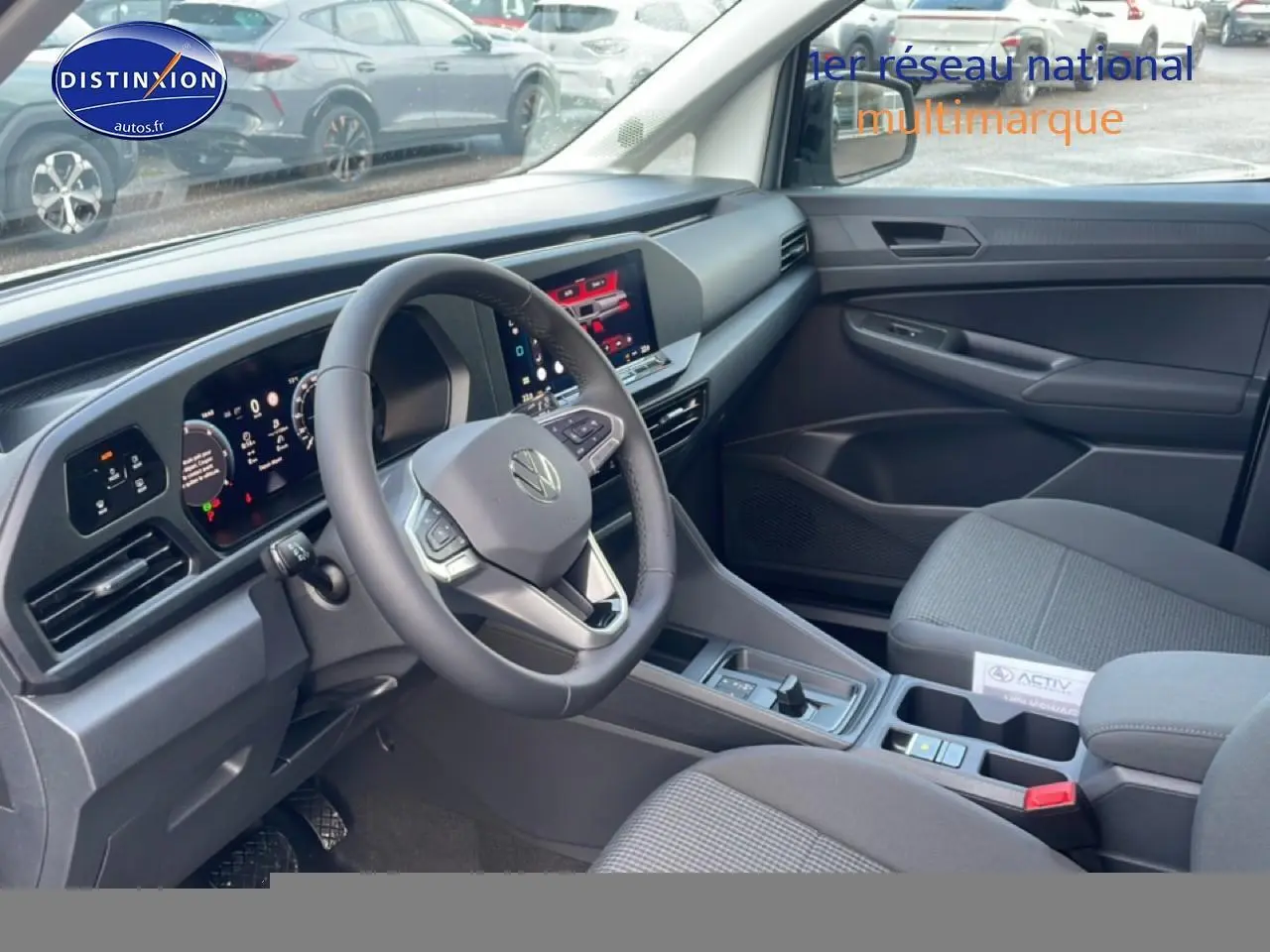 Vue intérieure côté conducteur du Volkswagen Caddy 2.0 TDI 122 DSG7 2025 avec volant cuir multifonction et écran tactile.