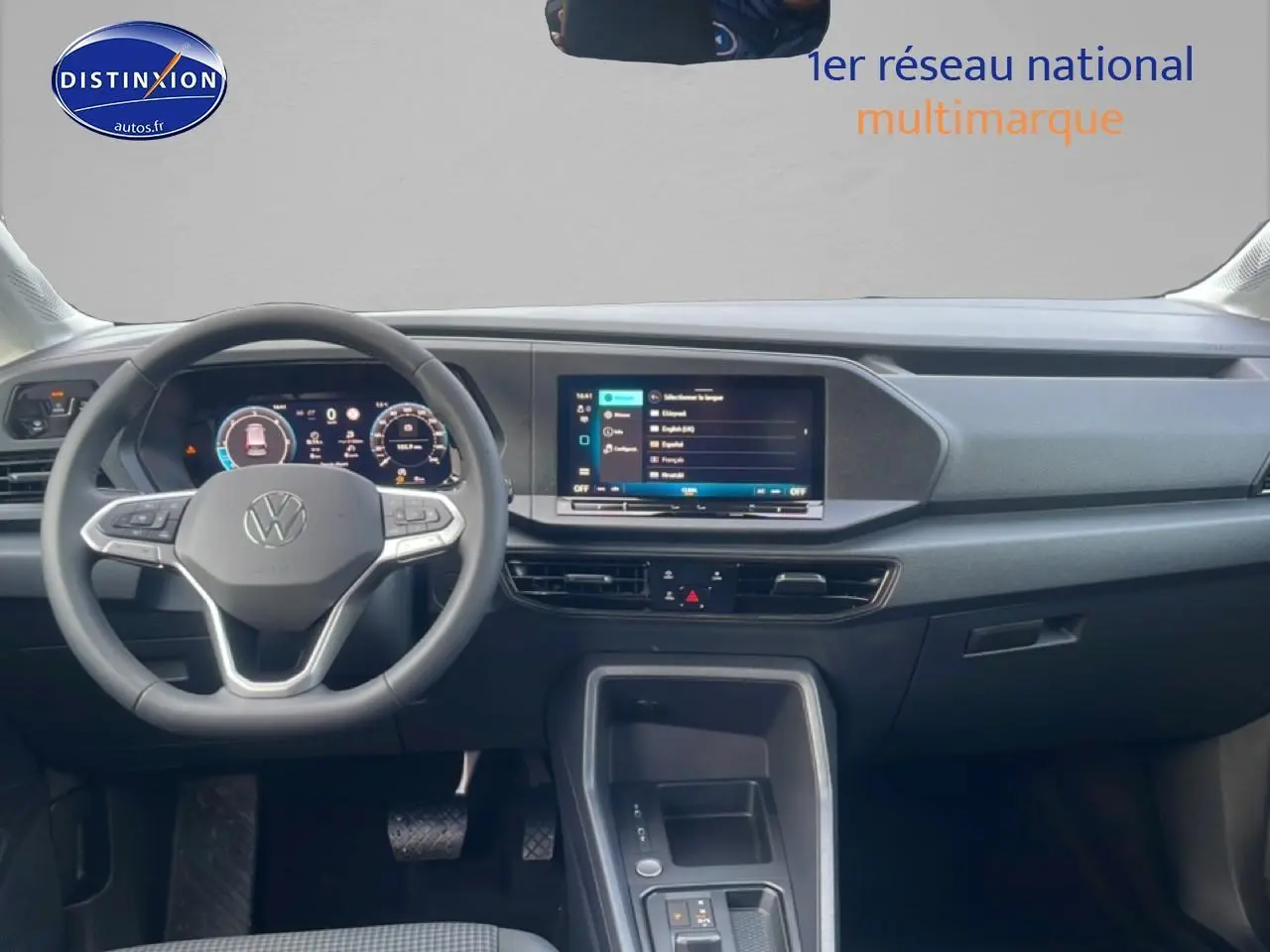 Vue intérieure frontale du tableau de bord noir du Volkswagen Caddy 2.0 TDI 122 DSG7 avec écran tactile et volant multifonction.