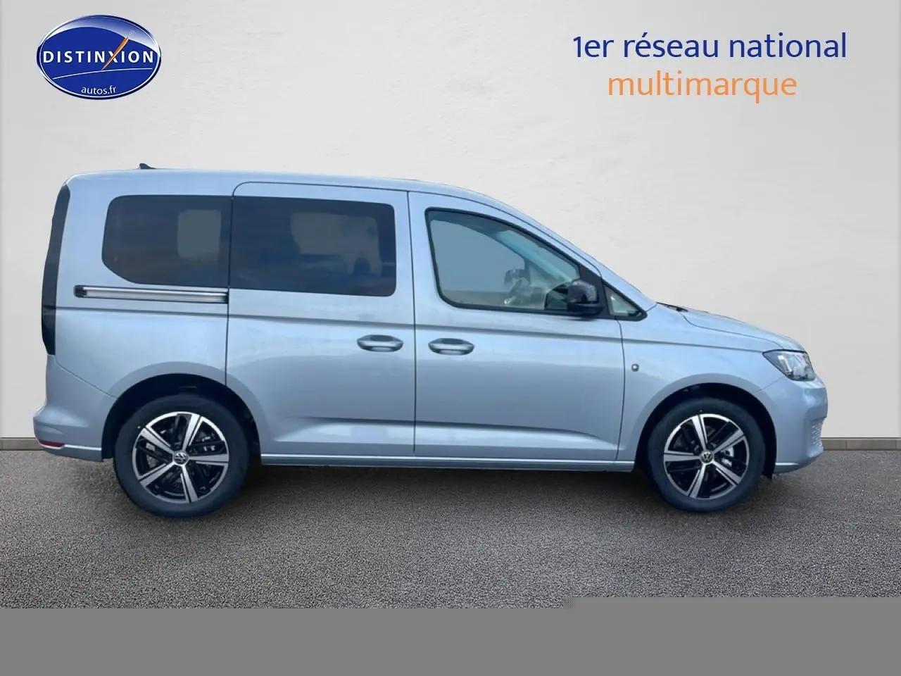 Profil droit d'un Volkswagen Caddy gris argent 2025 avec vitres teintées et jantes alliage noires.