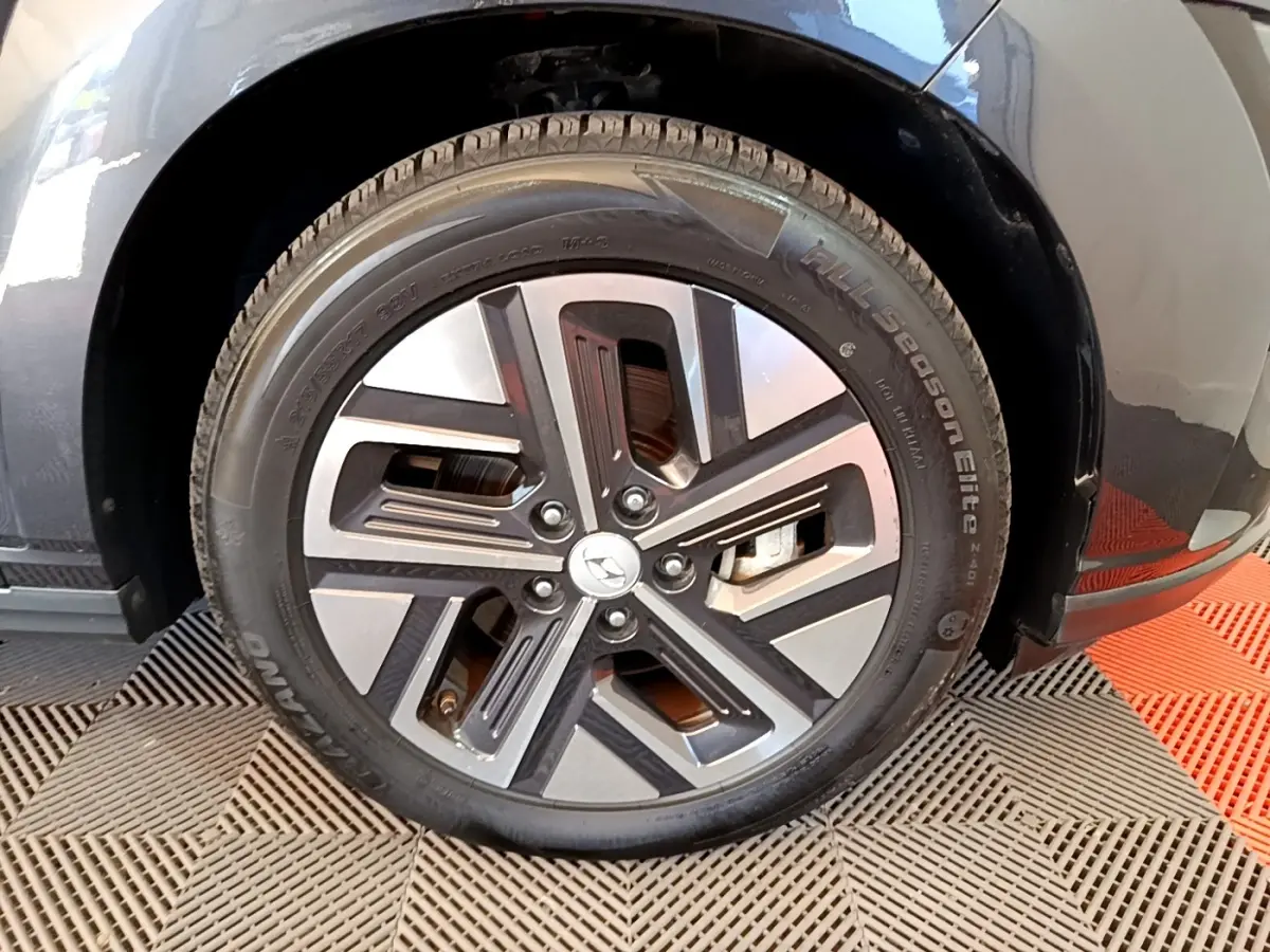 Gros plan sur la roue avant droite d'une Hyundai Kona électrique noire avec jante alliage bicolore moderne.