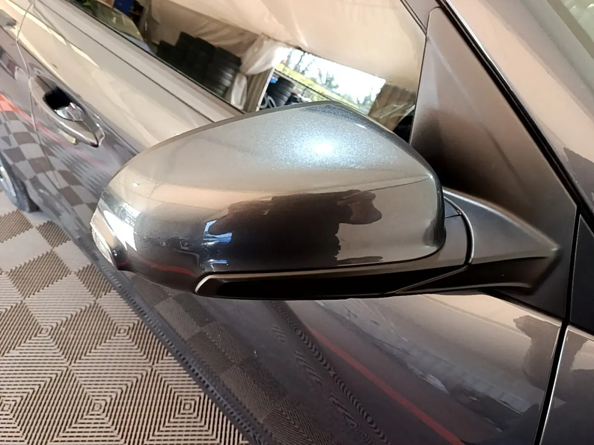 Rétroviseur côté conducteur gris métallisé de Hyundai Kona électrique 2021, vue rapprochée avec portière visible.