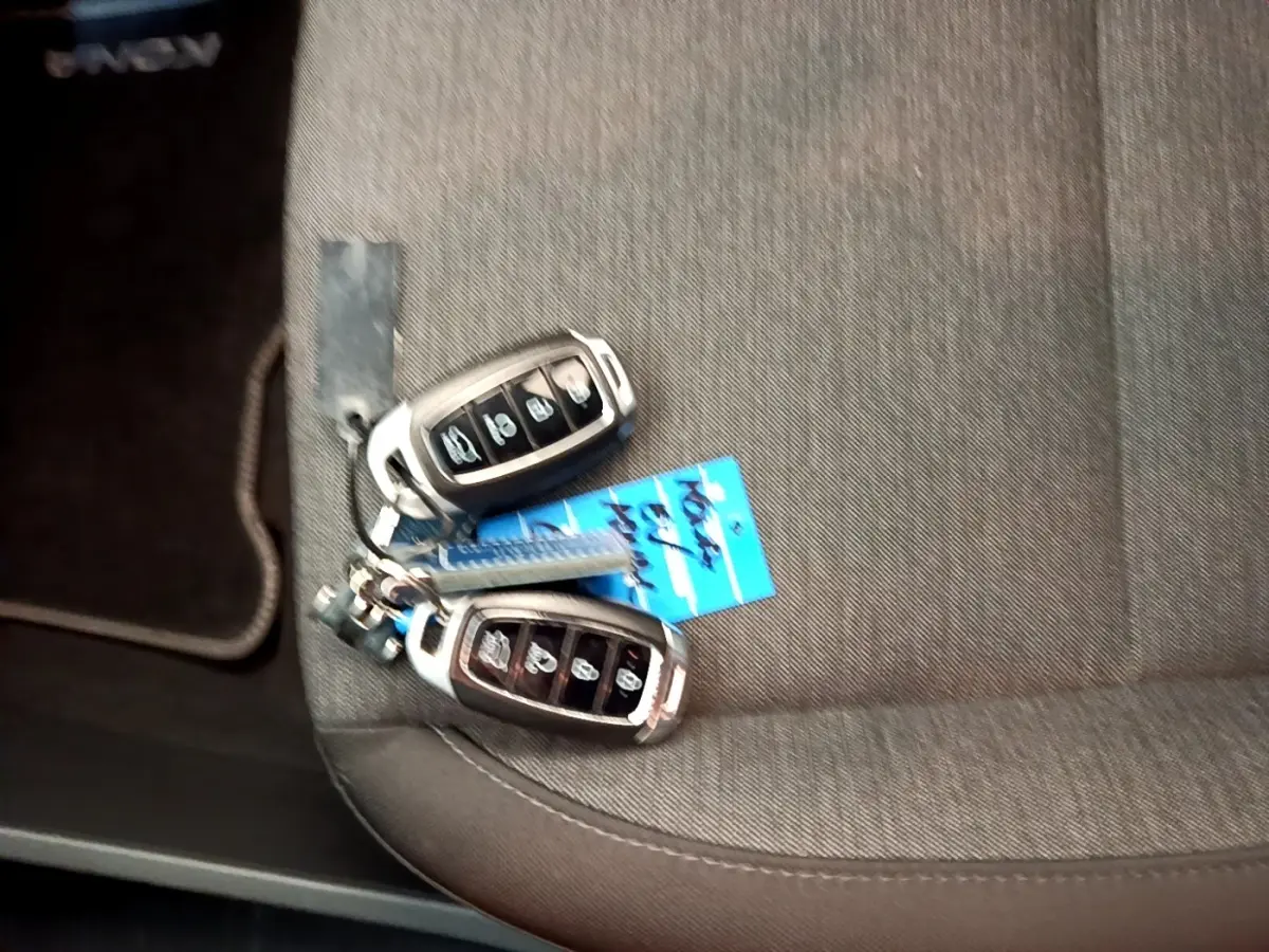 Gros plan sur deux clés de voiture Hyundai posées sur un siège tissu gris à l'intérieur du véhicule.