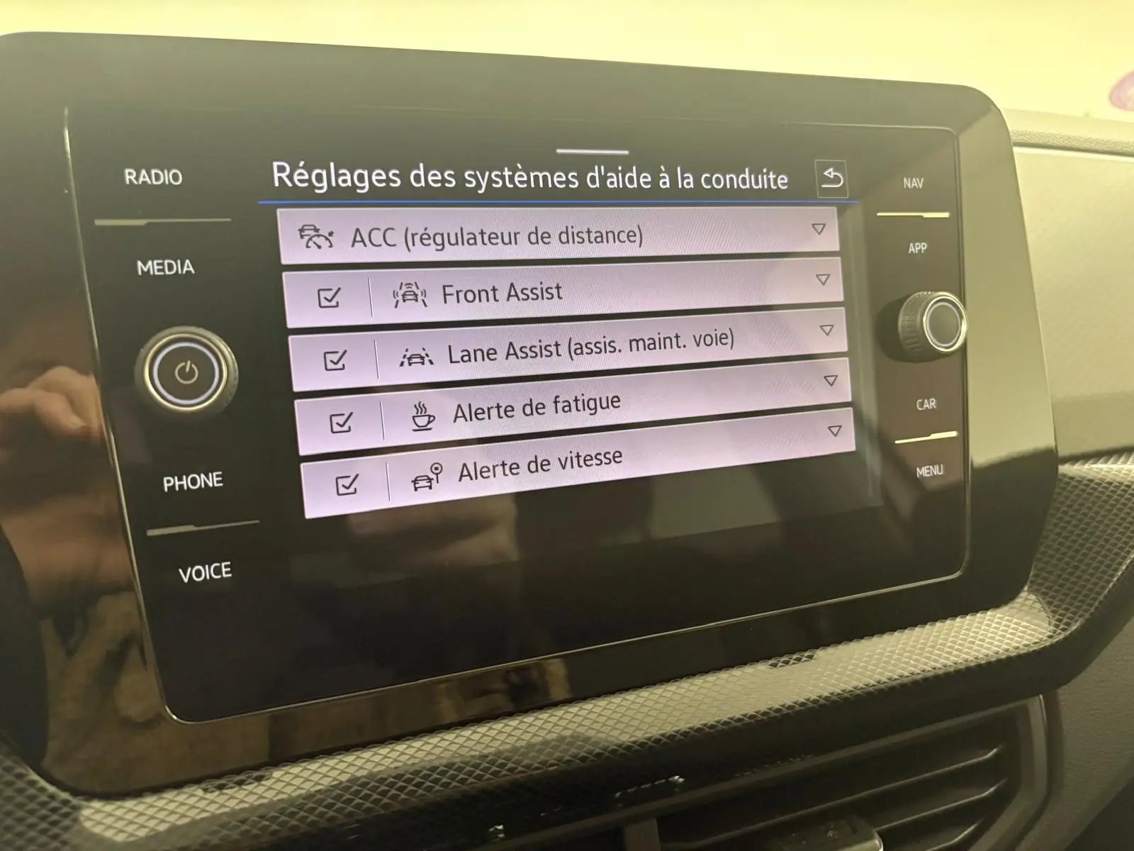 Écran tactile intérieur affichant les réglages d'aide à la conduite du Volkswagen T-Cross 2024, version Reflet d'Argent.