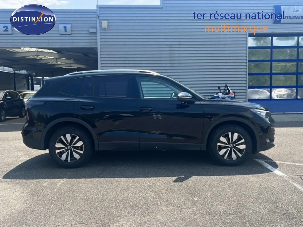 Vue de profil côté gauche du Volkswagen Tiguan noir Grenadilla 2026 avec jantes distinctives et lignes épurées.
