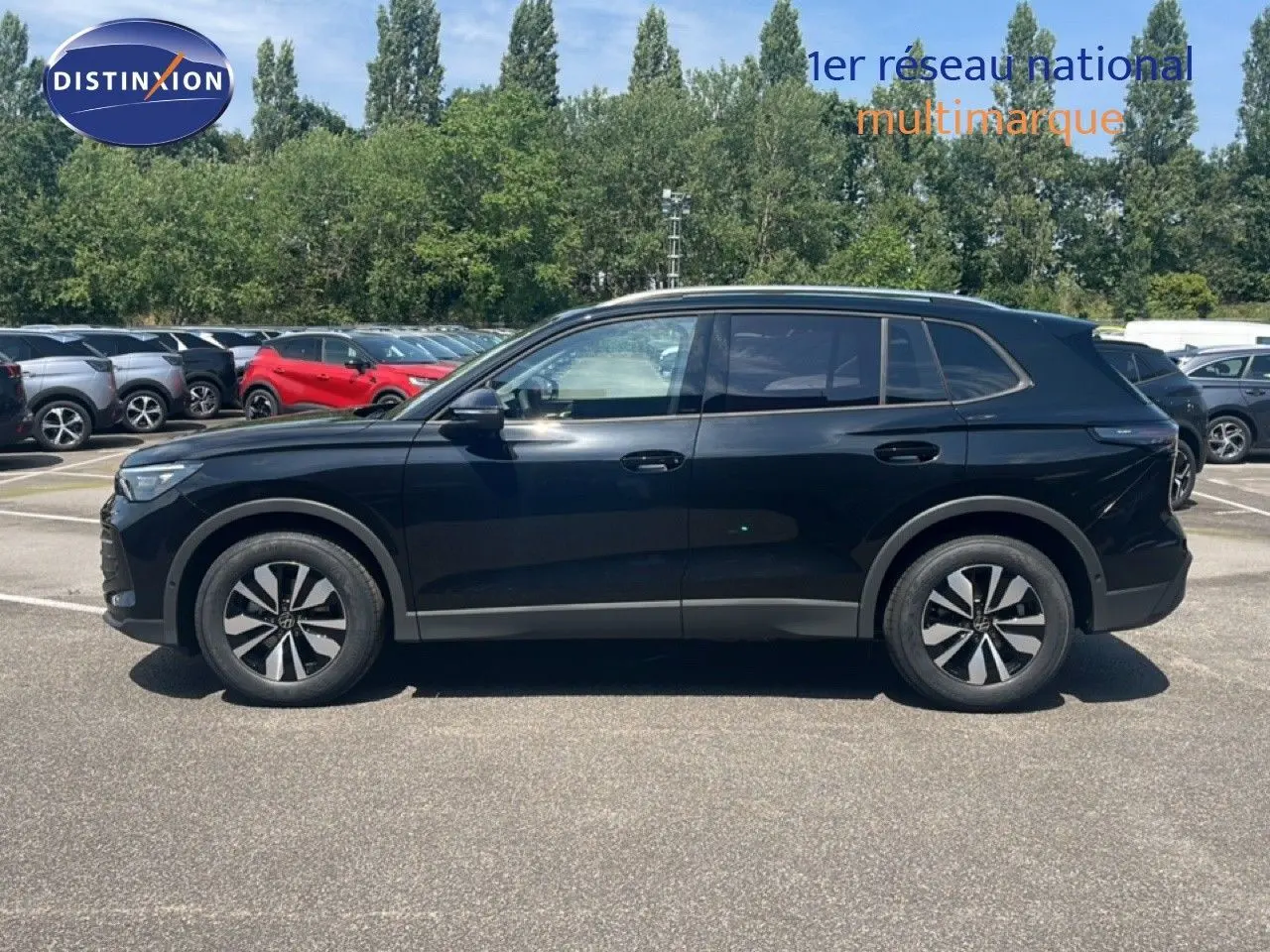 Vue de profil côté gauche d'un Volkswagen Tiguan noir Grenadilla métallisé, avec jantes bi-ton et lignes épurées.