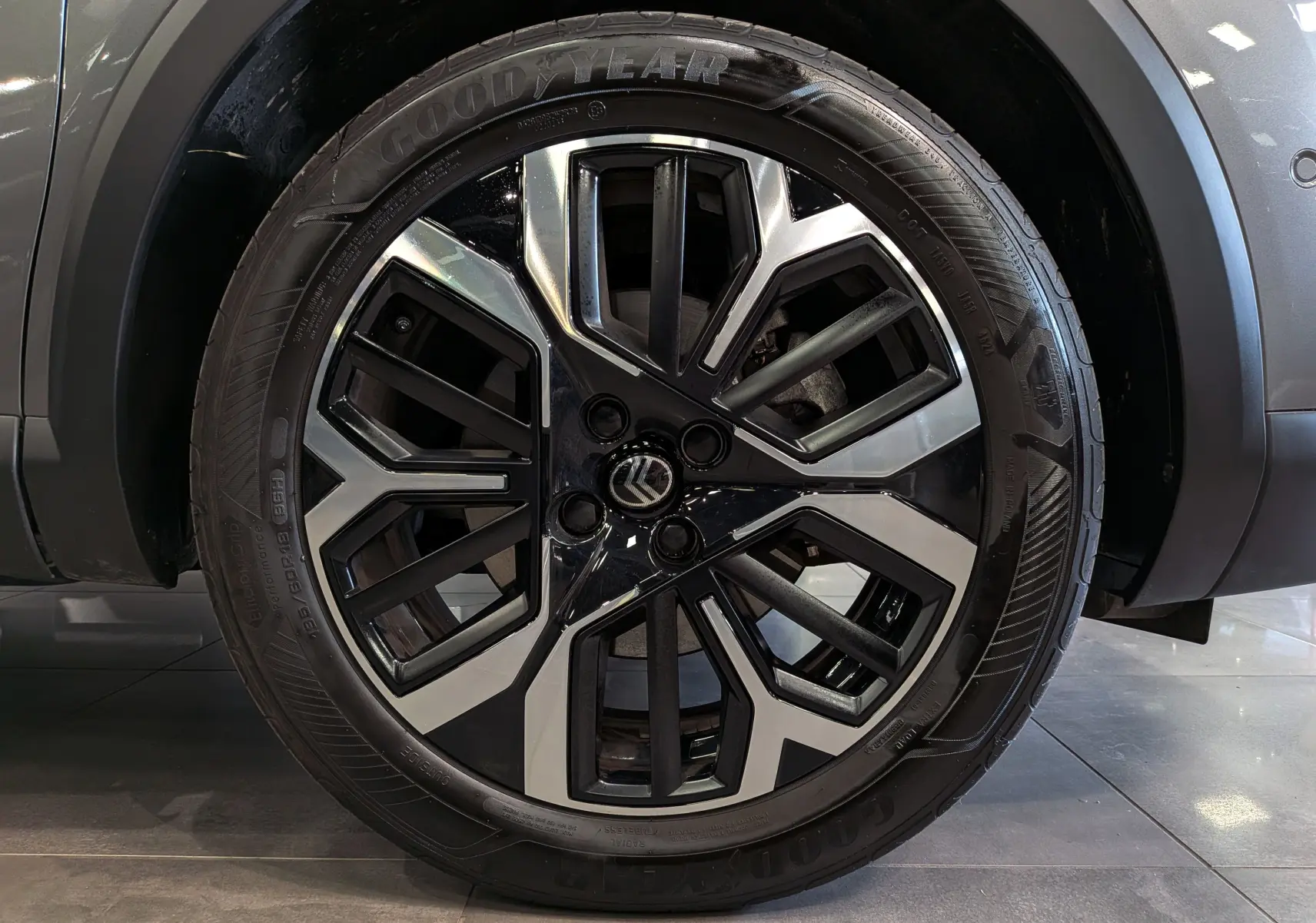 Gros plan sur la jante biton noir et argent de la Citroën C4 Hybride gris Mercury, avec pneu Goodyear visible.