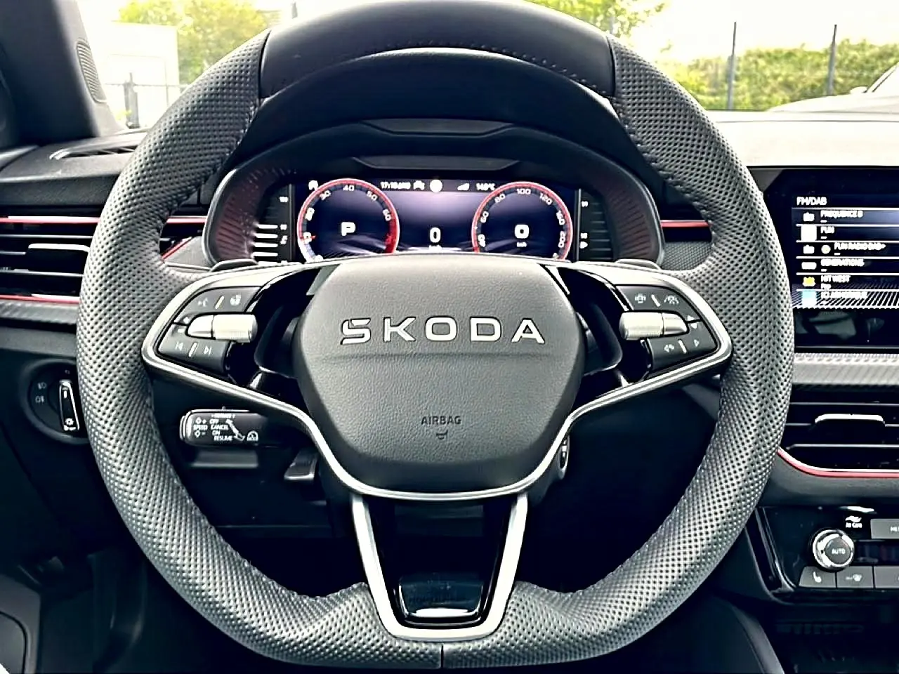 Vue rapprochée du volant sport en cuir perforé noir du Skoda Kamiq 2026 avec tableau de bord numérique et inserts rouges.