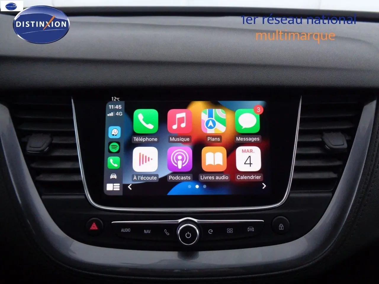 Écran tactile central avec interface Apple CarPlay dans l'habitacle d'un Opel Grandland X blanc nacré hybride rechargeable.
