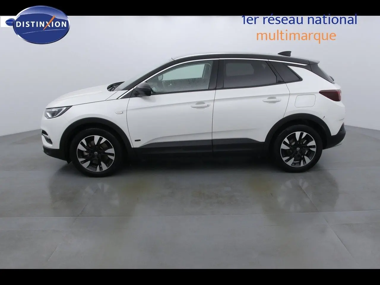 Vue latérale droite d'un Opel Grandland X blanc nacré avec jantes noires et toit noir contrastant.
