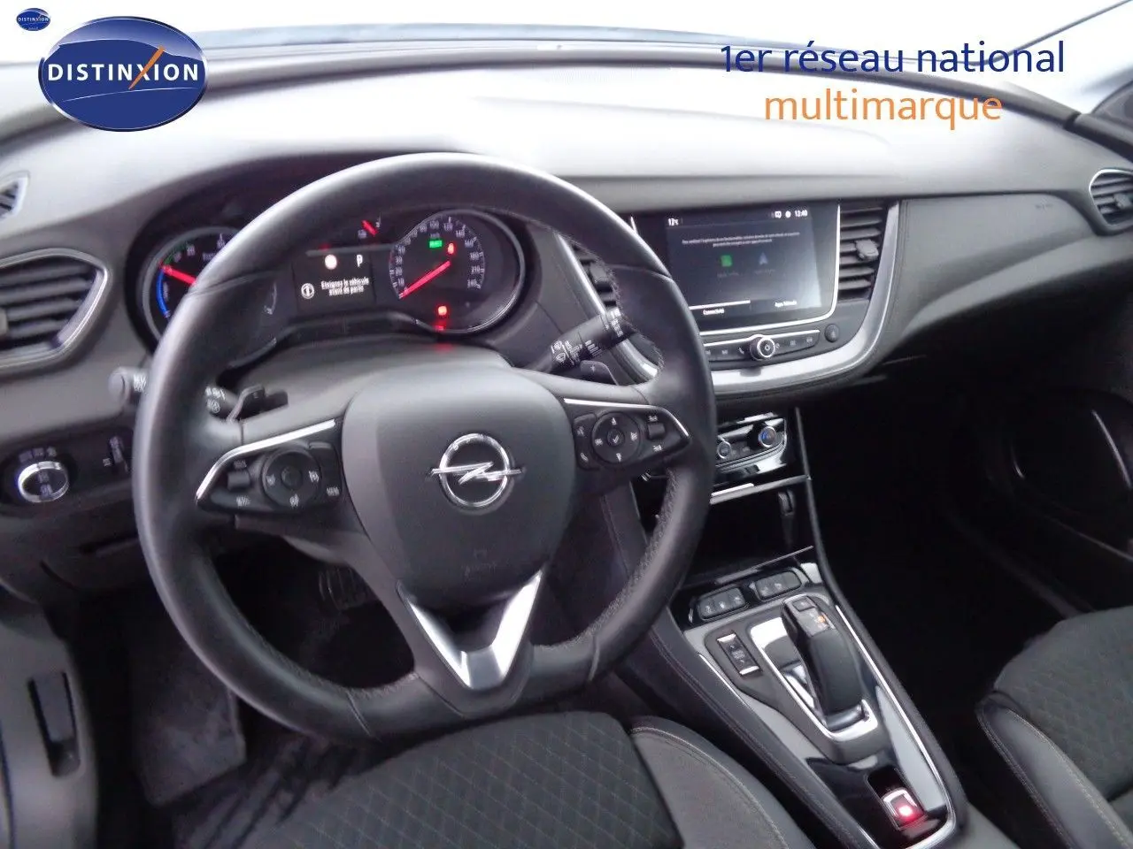 Vue intérieure centrée sur le volant Opel Grandland X 1.6 Hybrid Turbo 2021 avec tableau de bord et console noire.