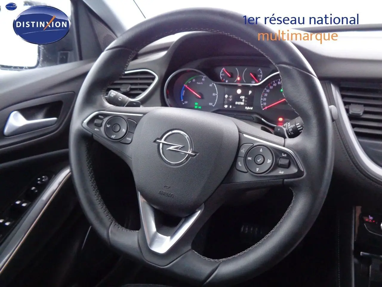 Vue rapprochée du volant en cuir noir de l'Opel Grandland X 1.6 Hybrid Turbo 2021 avec tableau de bord numérique visible.