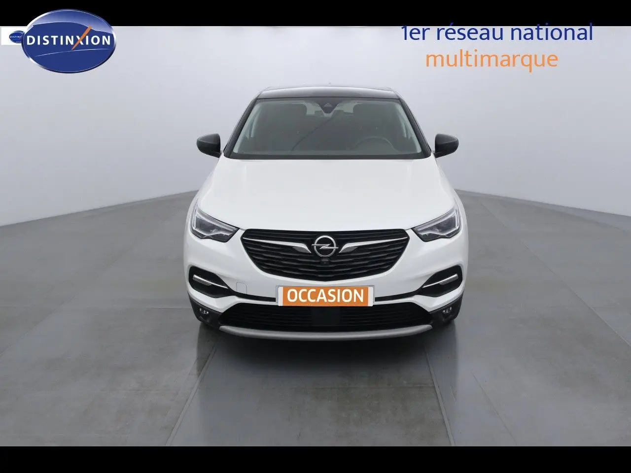Vue frontale d'un Opel Grandland X blanc nacré métal avec calandre noire et plaque "OCCASION" visible.