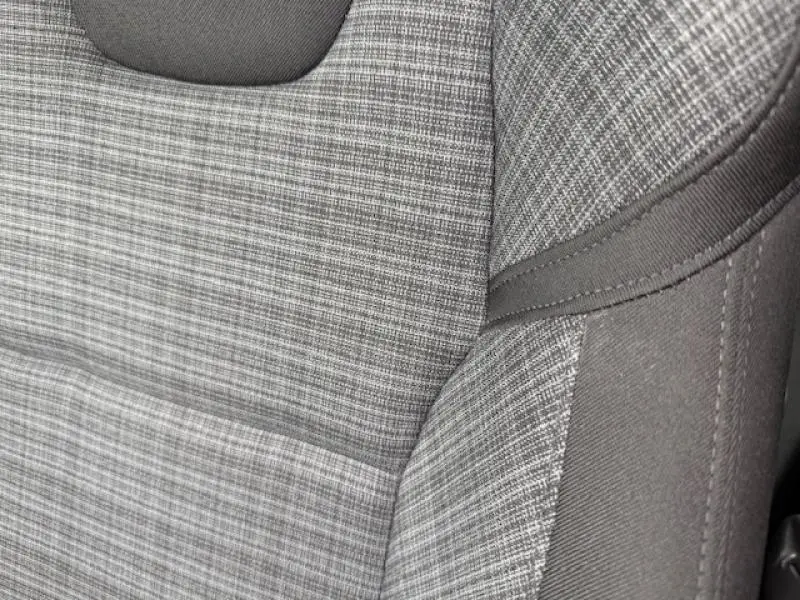 Détail du tissu gris à motifs du siège avant de la Volvo S60 2024 Rouge Fusion Métallisé hybride essence.