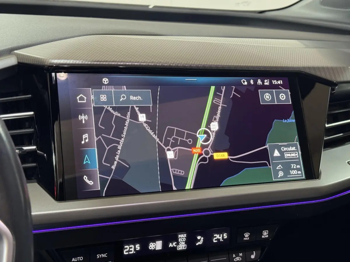 Écran tactile central du tableau de bord de l'Audi Q4 E-TRON gris foncé, affichant la navigation GPS en vue satellite.