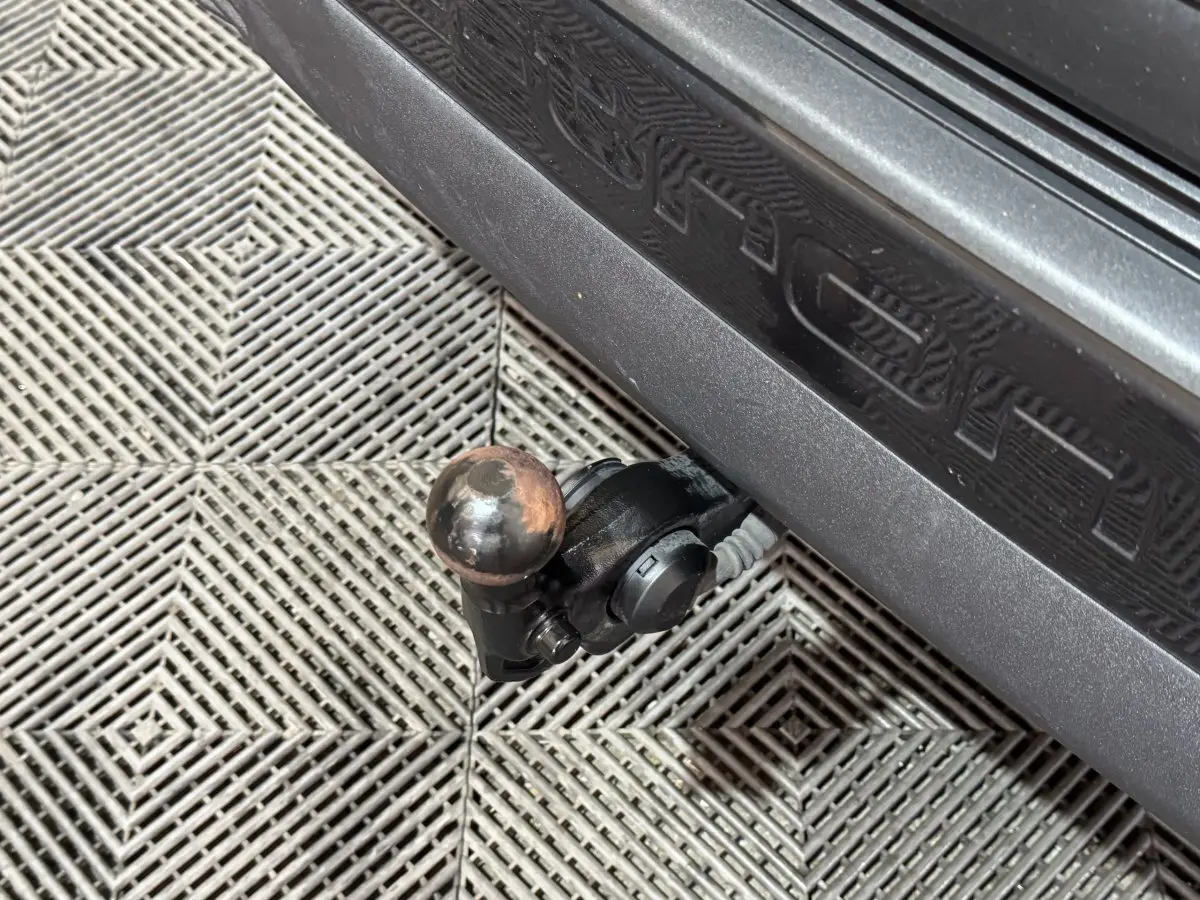 Gros plan sur l'attelage de remorque noir fixé sous le seuil gris foncé de l'Audi Q4 E-TRON Design Luxe 2022.