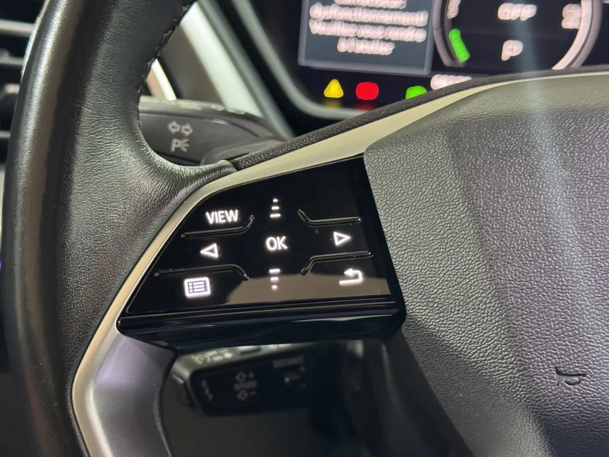 Gros plan sur les commandes tactiles gauche du volant cuir noir d’un Audi Q4 E-TRON 2022 électrique.