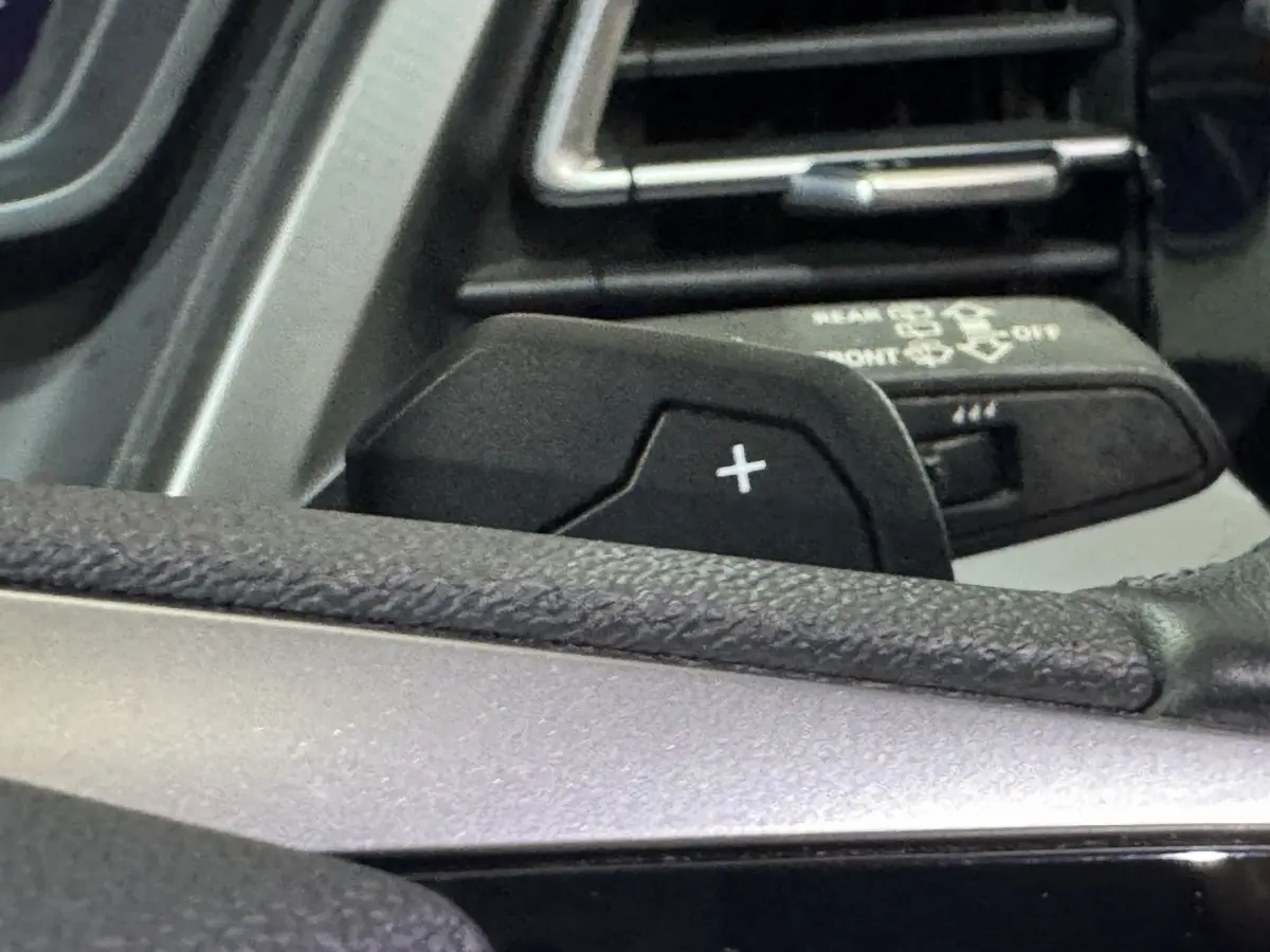 Gros plan sur la palette de changement de vitesse "+" côté gauche du volant dans l'Audi Q4 E-TRON gris foncé 2022.