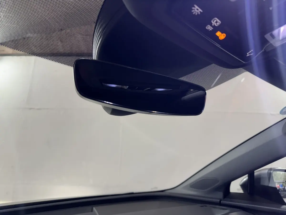 Rétroviseur intérieur noir et tableau de bord supérieur d'un Audi Q4 E-TRON Design Luxe gris foncé, vue de l'habitacle côté conducteur.