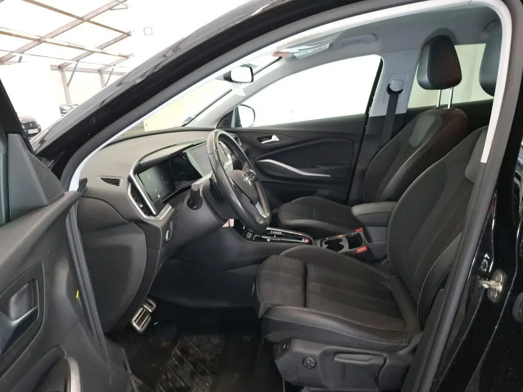 Vue intérieure côté conducteur de l’Opel Grandland noir 2023, montrant les sièges, le volant et la console centrale.