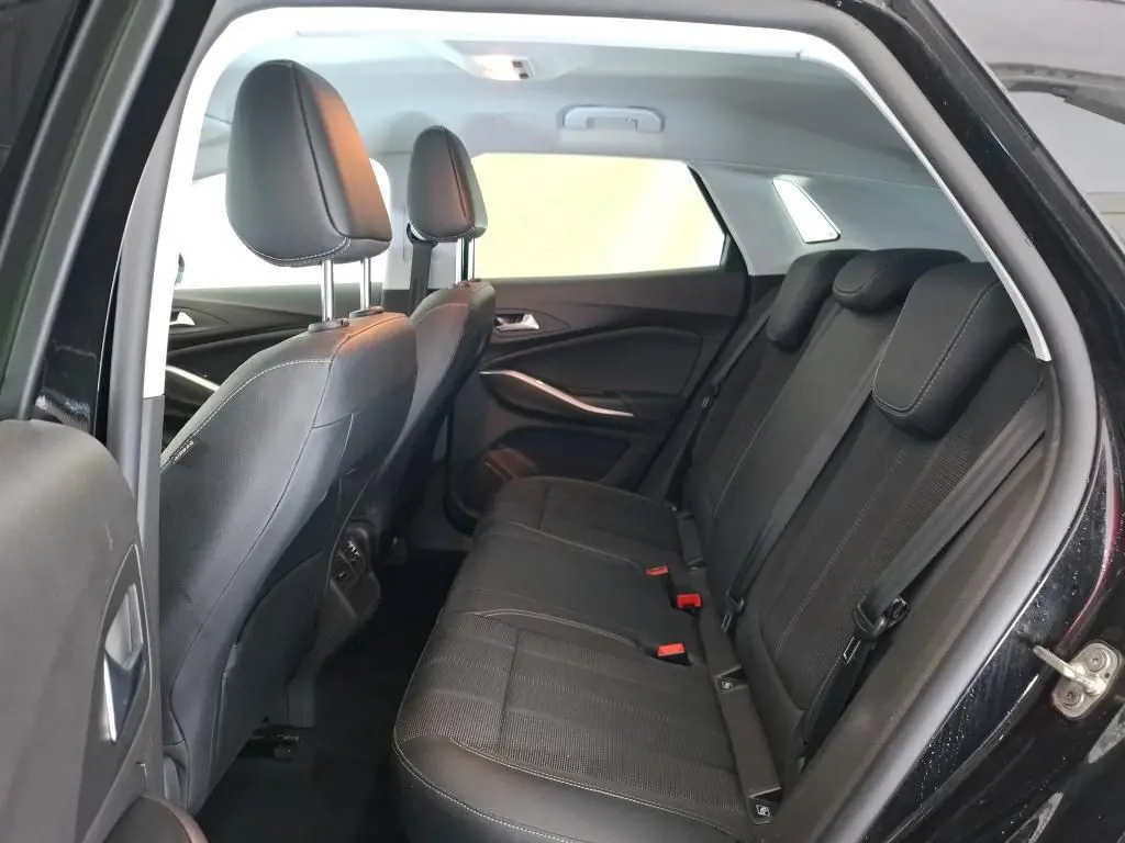 Vue intérieure côté droit des sièges arrière noirs de l’Opel Grandland 2023 avec détails des appuie-têtes et ceintures.