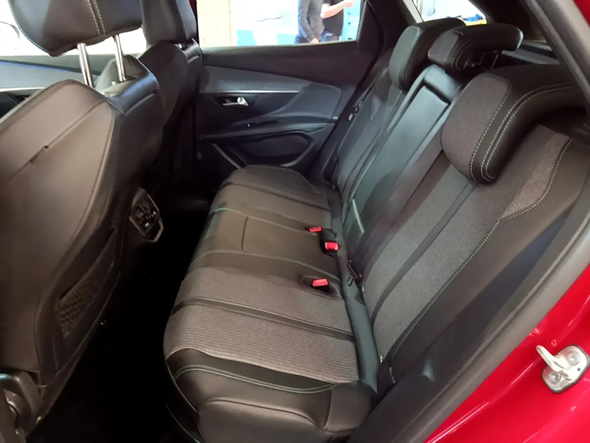 Vue latérale droite de la banquette arrière bi-matière grise et noire du Peugeot 3008 hybride rechargeable rouge.