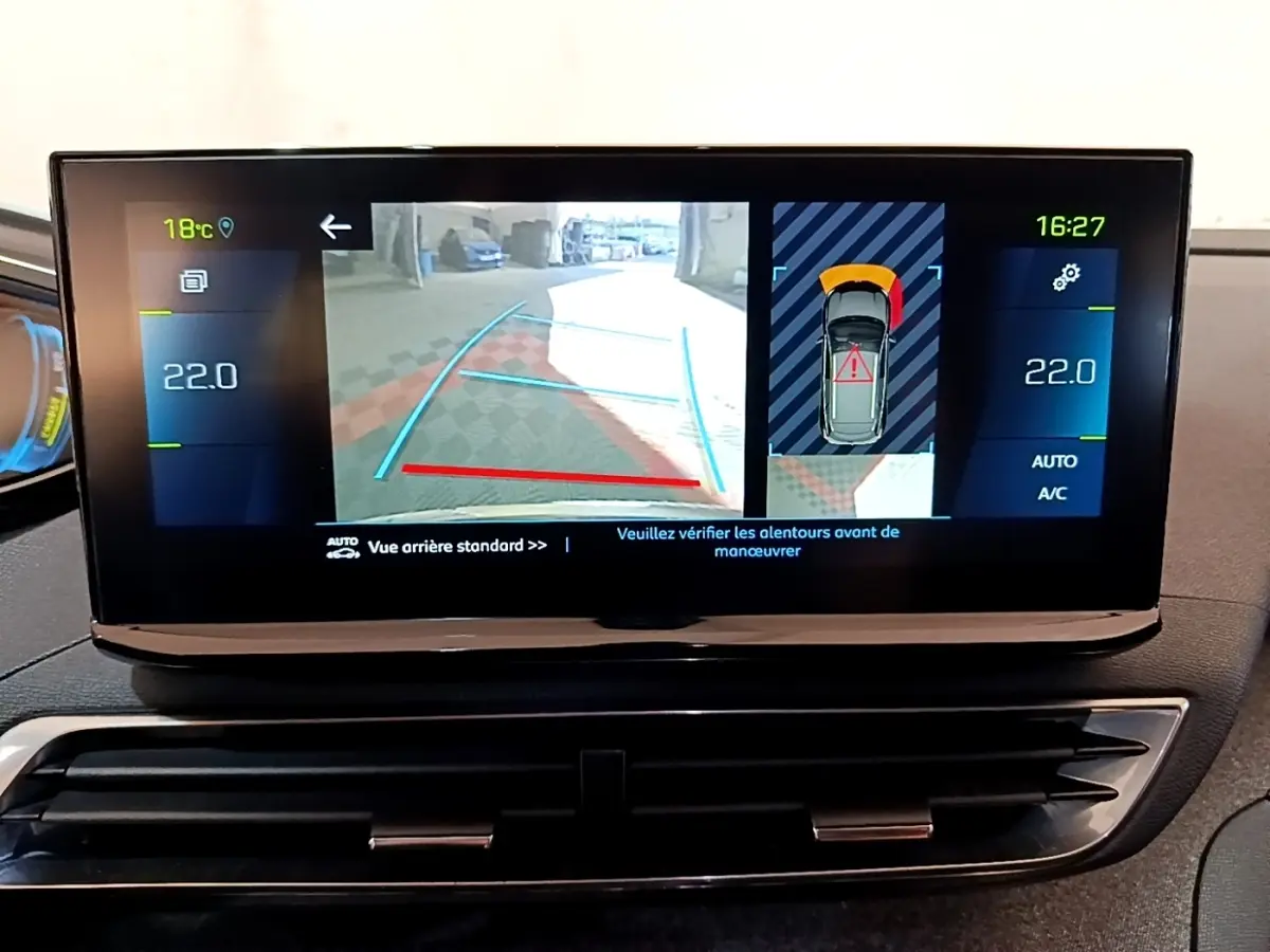 Écran tactile intérieur du Peugeot 3008 hybride montrant la caméra de recul et l'aide au stationnement en vue arrière.
