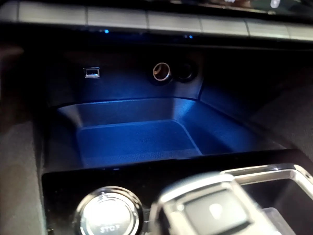 Gros plan sur la console centrale noire avec bouton démarrage et prises USB et allume-cigare du Peugeot 3008 hybride.