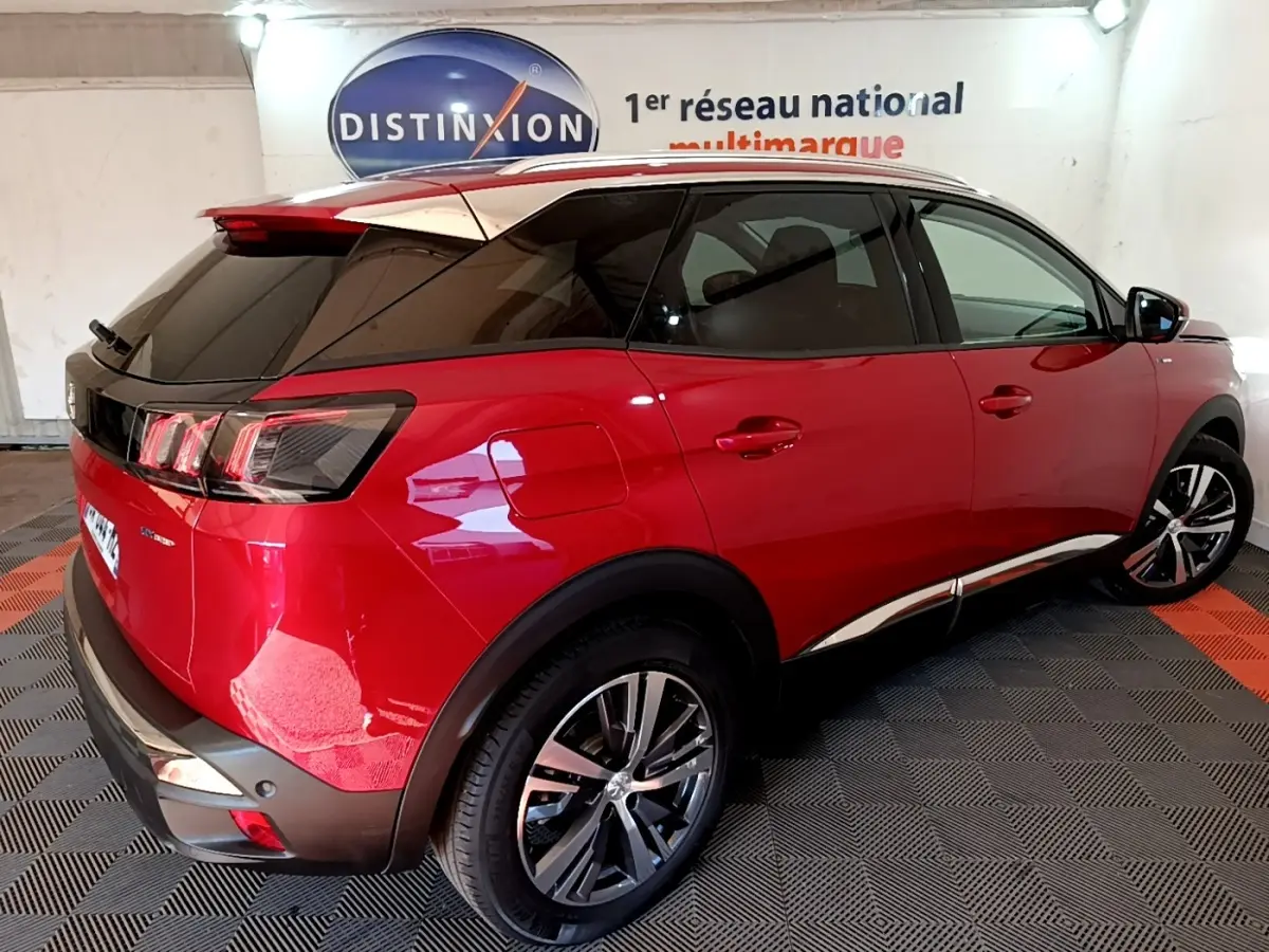Vue 3/4 arrière droite d’un Peugeot 3008 hybride rechargeable rouge avec toit noir et jantes alliage.