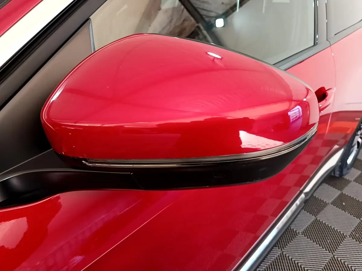Rétroviseur droit rouge brillant du Peugeot 3008 hybride rechargeable, vue rapprochée sur la portière côté droit.