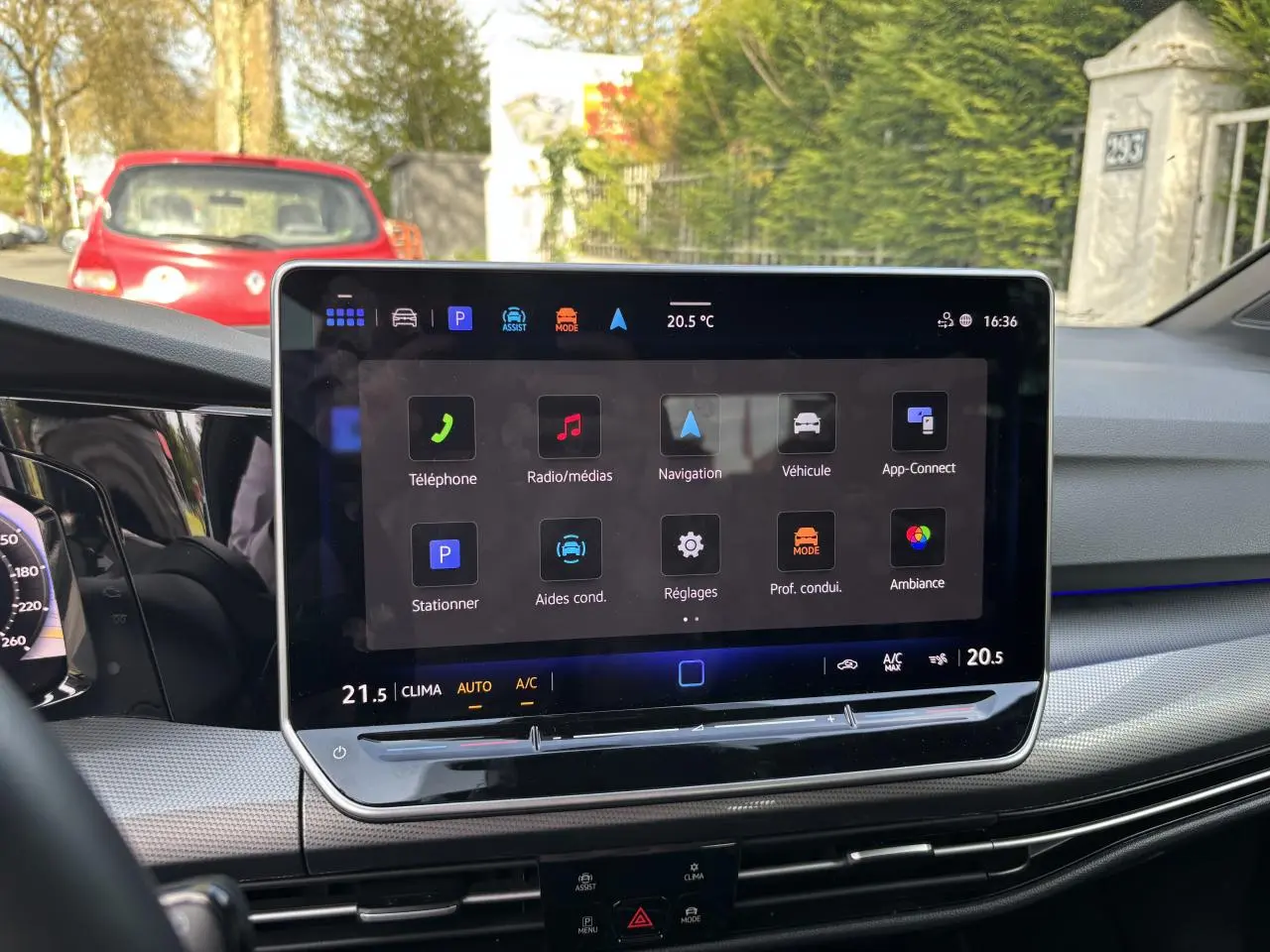 Vue intérieure du tableau de bord de la Volkswagen Golf 2024 blanc, avec écran tactile central affichant les options multimédia et navigation.