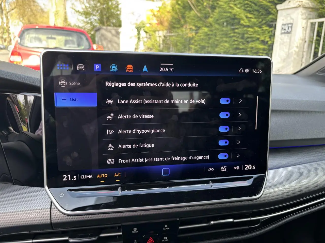 Écran tactile central de la Volkswagen Golf 2024 blanc, affichant les réglages des aides à la conduite.