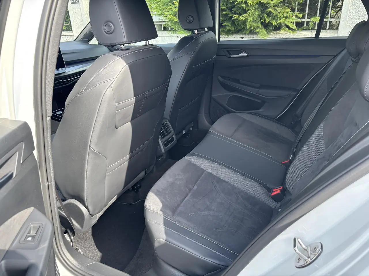 Vue intérieure arrière côté droit de la Volkswagen Golf 1.5 eTSI Edition 50 2024 avec sièges en cuir et tissu noirs.