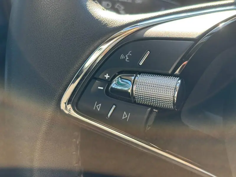 Gros plan sur les commandes audio au volant du Skoda Kamiq 1.5 TSI Ambition 2023, finition noire avec chrome.