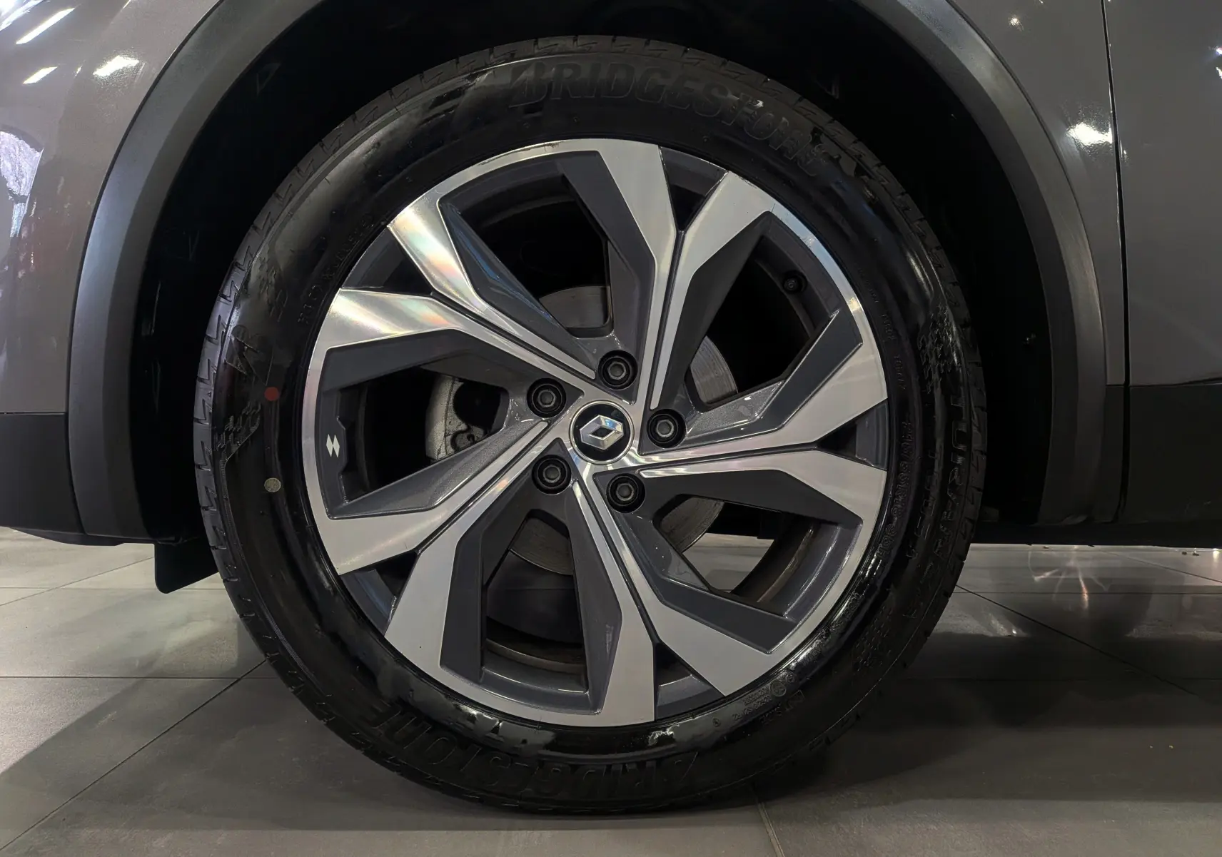 Gros plan sur la roue avant droite du Renault Captur TCe 160 R.S. Line gris Cassiopé avec jante alliage 18 pouces bi-ton.