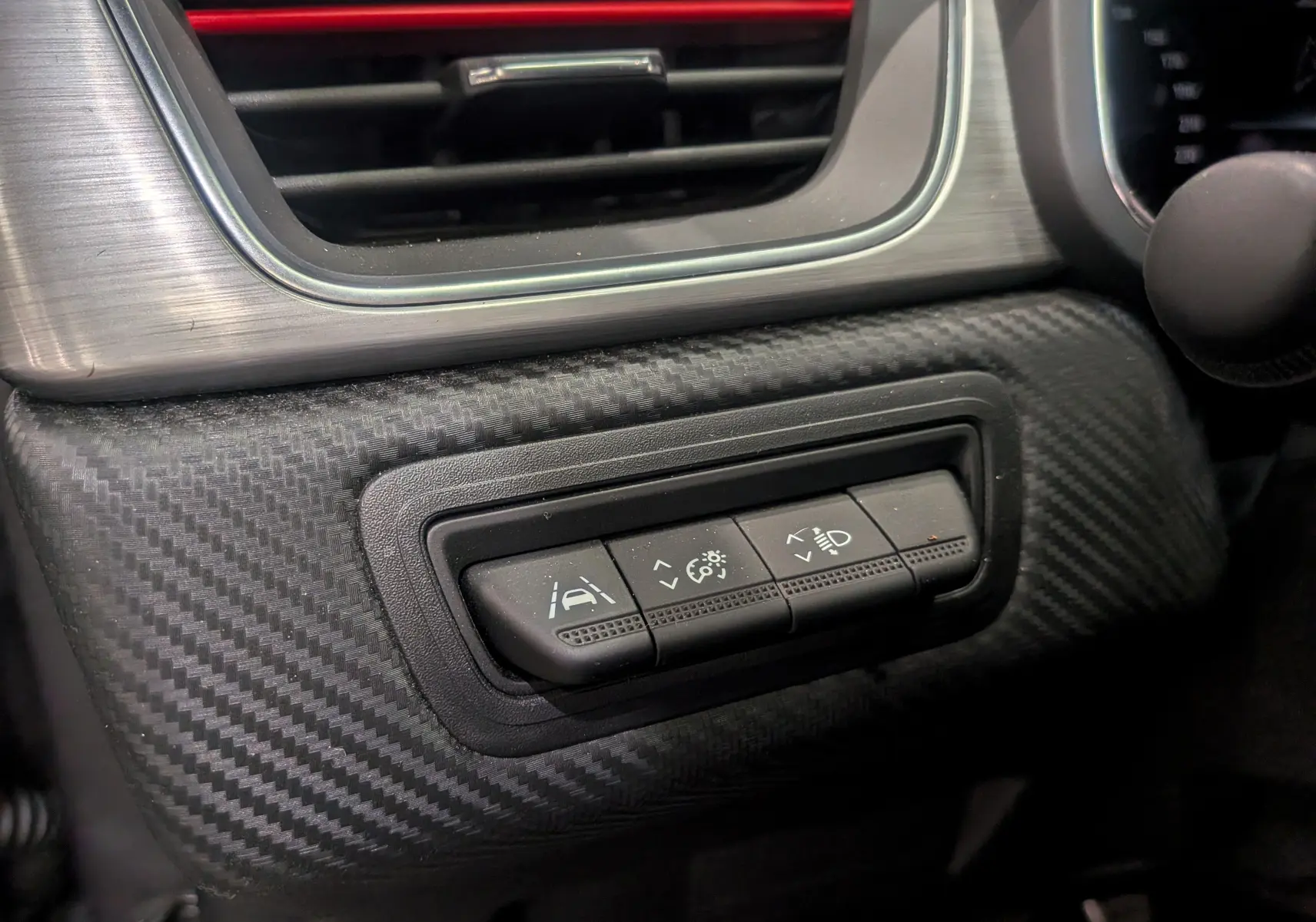Gros plan sur les commandes d'assistance à la conduite du tableau de bord en carbone du Renault Captur TCe 160 R.S. Line 2022.