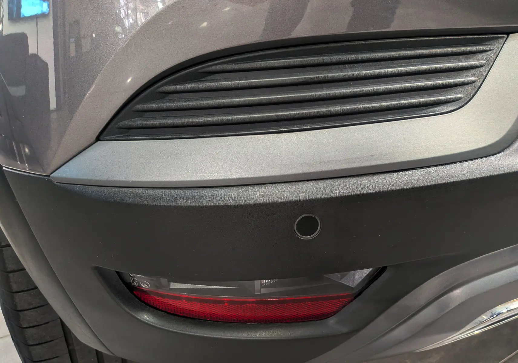 Gros plan sur le feu arrière droit et la partie inférieure gris cassiopé du pare-chocs du Renault Captur TCe 160 R.S. Line.