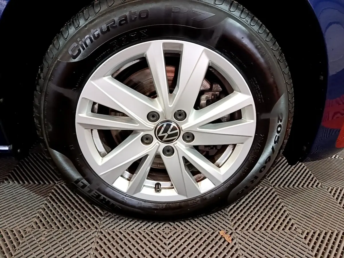 Gros plan sur la roue avant droite bleu d’un Volkswagen Touran 1.5 TSI EVO DSG7 United avec jante alliage argentée.