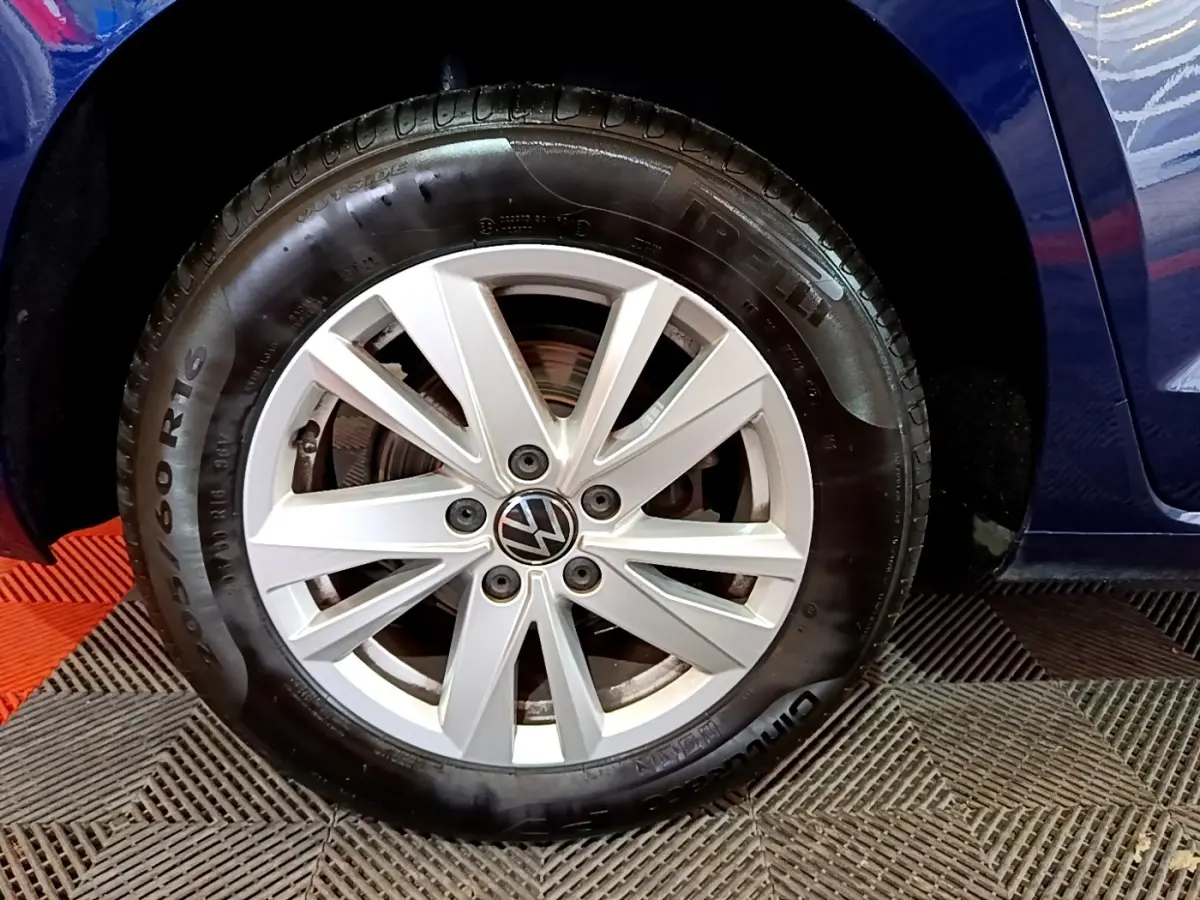 Gros plan sur la roue avant gauche d'un Volkswagen Touran bleu 2021 avec jante alliage et pneu Pirelli.