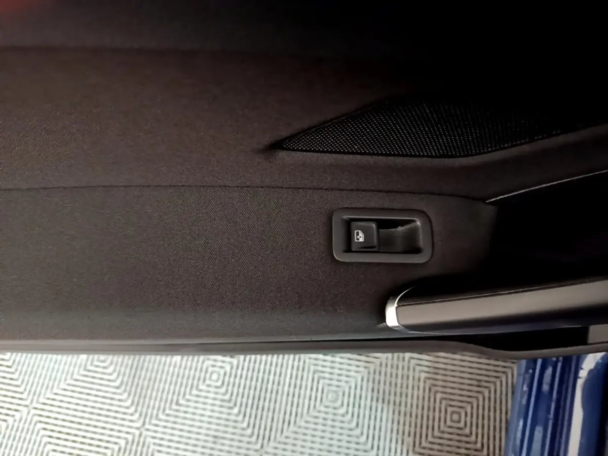 Détail de la poignée intérieure et bouton de verrouillage sur la porte côté gauche d’un Volkswagen Touran bleu 2021