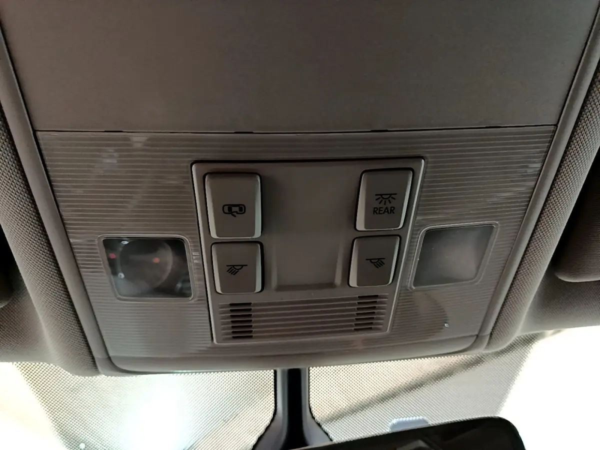 Vue en gros plan du plafonnier gris avec commandes d'éclairage et ouverture du toit du Volkswagen Touran 2021.