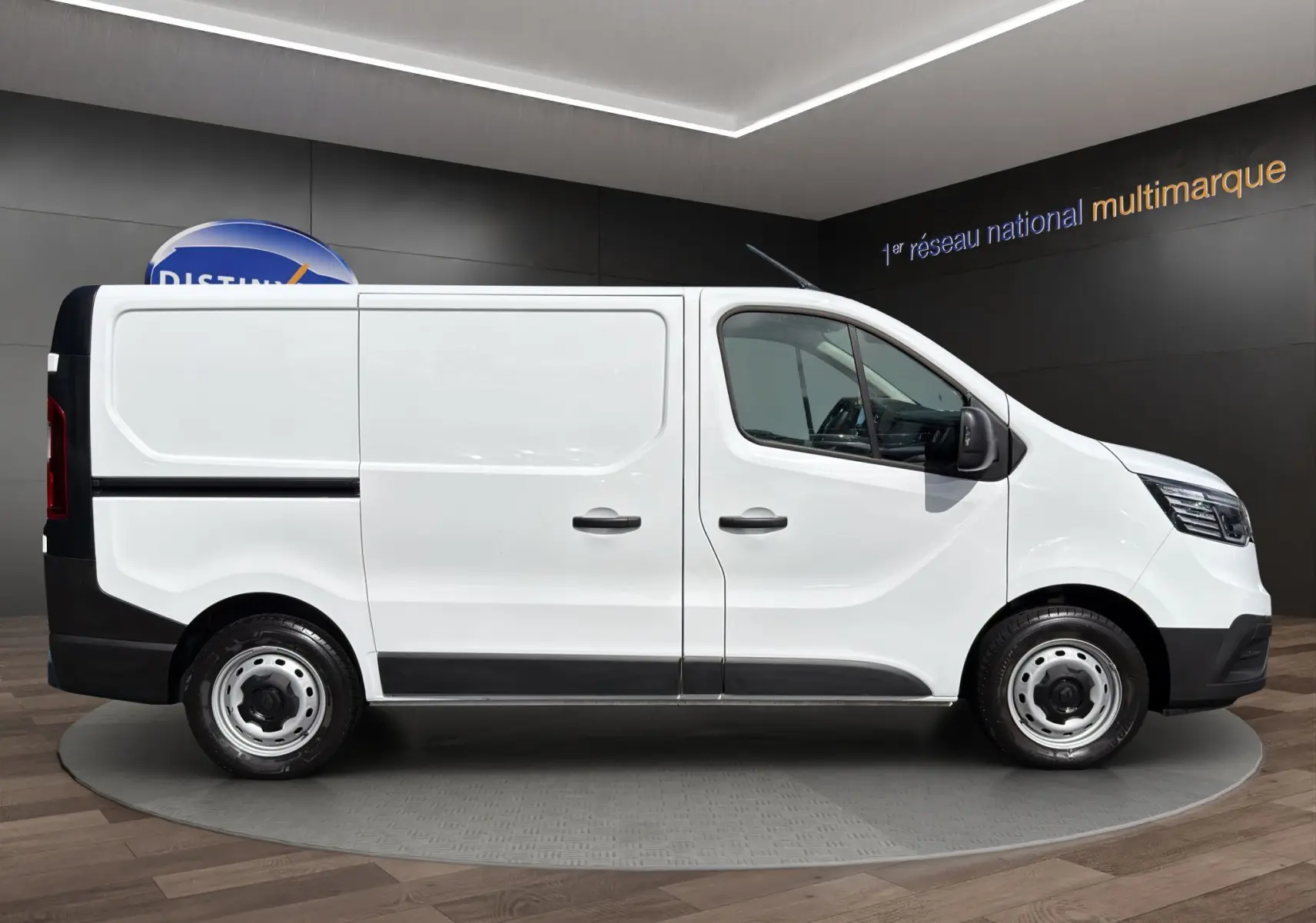 Profil droit du Renault Trafic Fourgon blanc 2024, avec portes latérales et jantes acier simples.