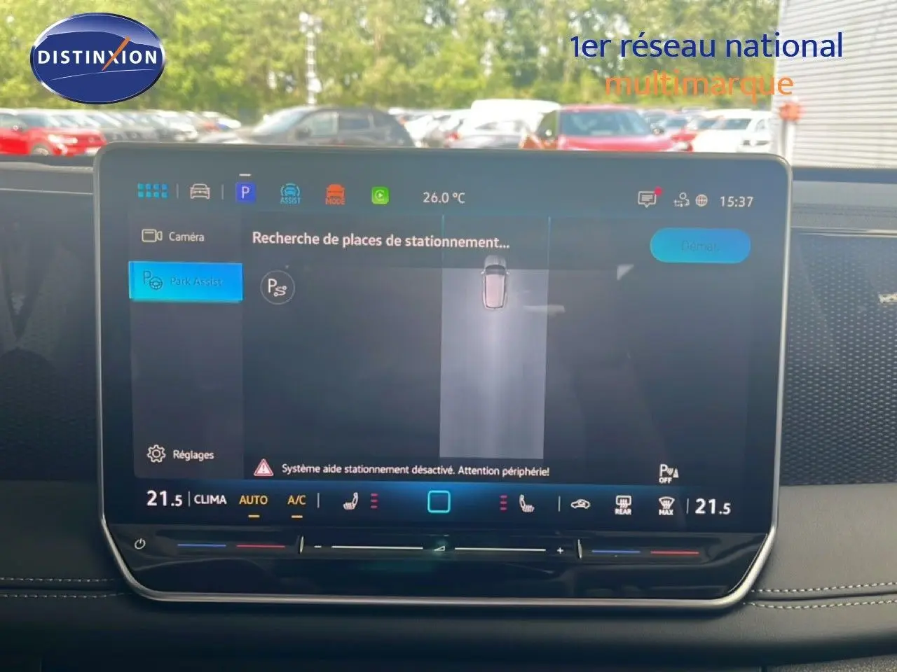 Vue intérieure centrée sur l'écran tactile du tableau de bord du Volkswagen Tiguan noir Grenadilla, affichant l'assistance au stationnement.