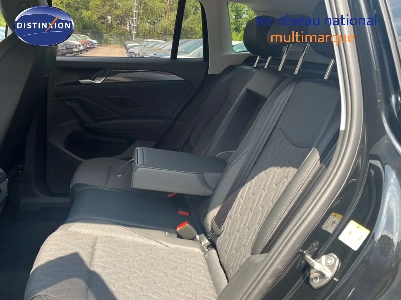 Vue intérieure côté droit sur les sièges arrière gris et noir du Volkswagen Tiguan noir Grenadilla 2026 avec accoudoir central déployé.