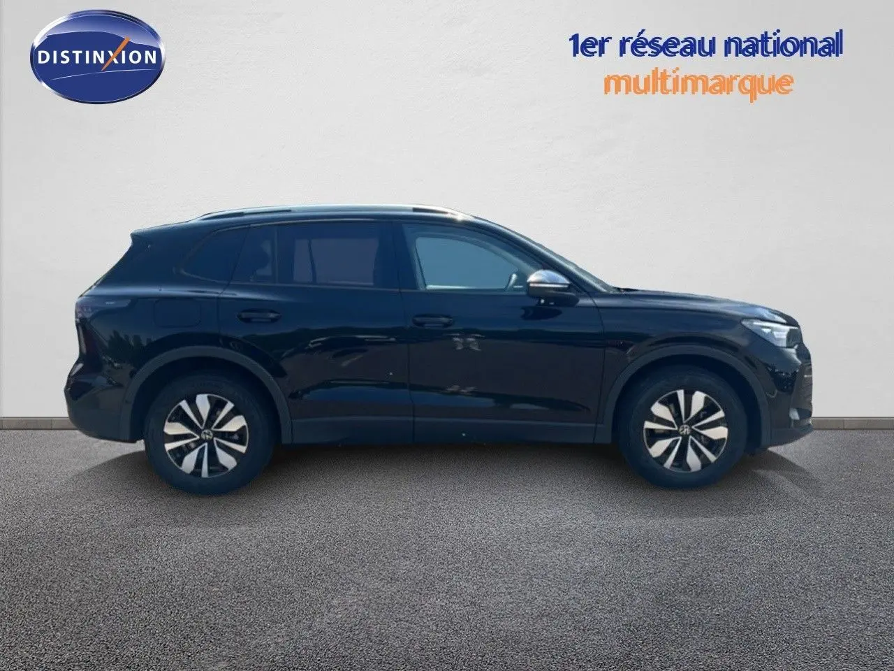 Vue de profil côté gauche d'un Volkswagen Tiguan noir Grenadilla métallisé, avec jantes bicolores et lignes épurées.