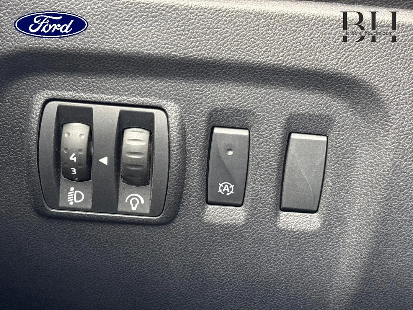 Tableau de bord avec commandes d'éclairage et arrêt auto moteur du Renault Captur gris Cassiopée, vue rapprochée.