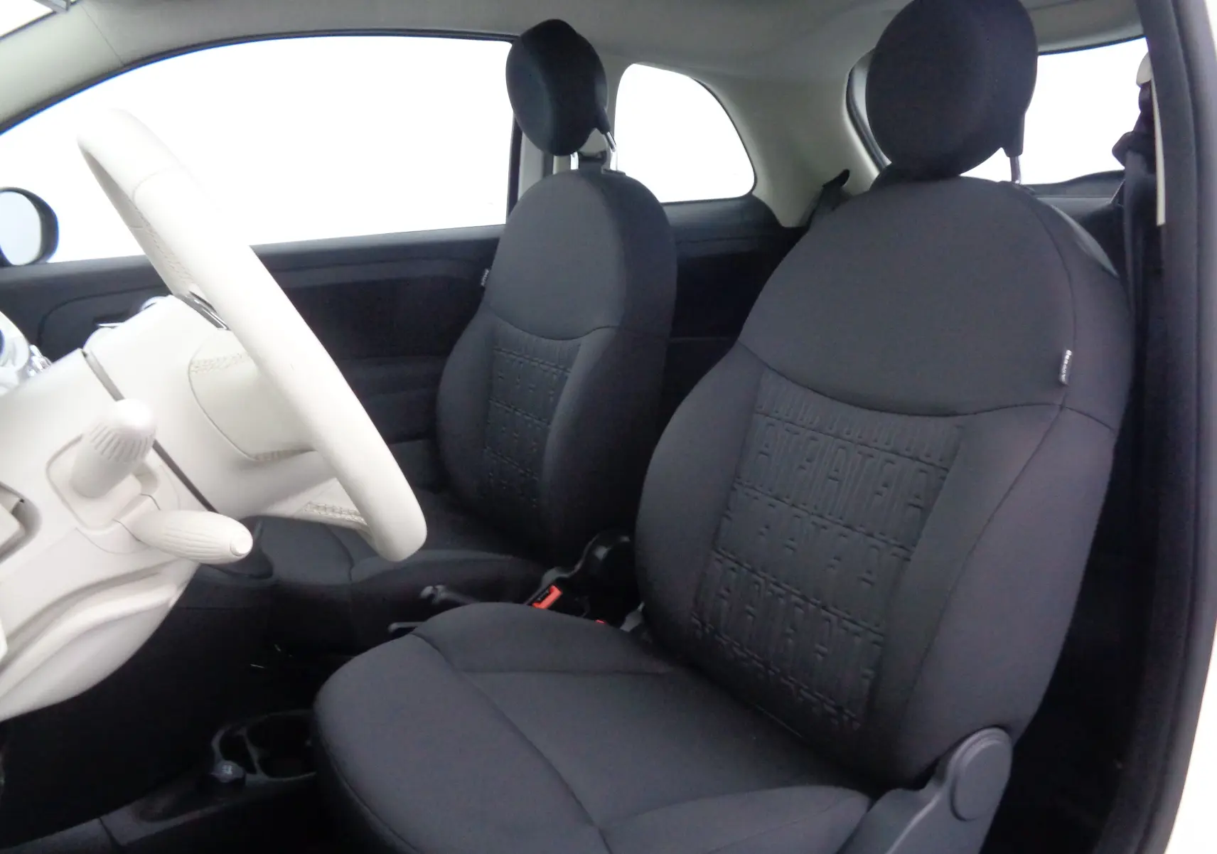Vue intérieure avant gauche du Fiat 500 1.0 Hybrid 70ch avec sièges noirs et volant blanc Gelato.