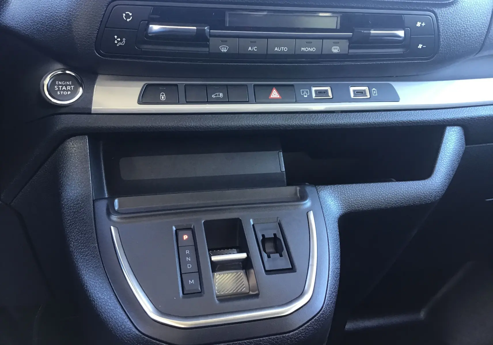Vue rapprochée de la console centrale du Peugeot Expert Fourgon 2024, avec bouton start/stop et commandes climatisation.