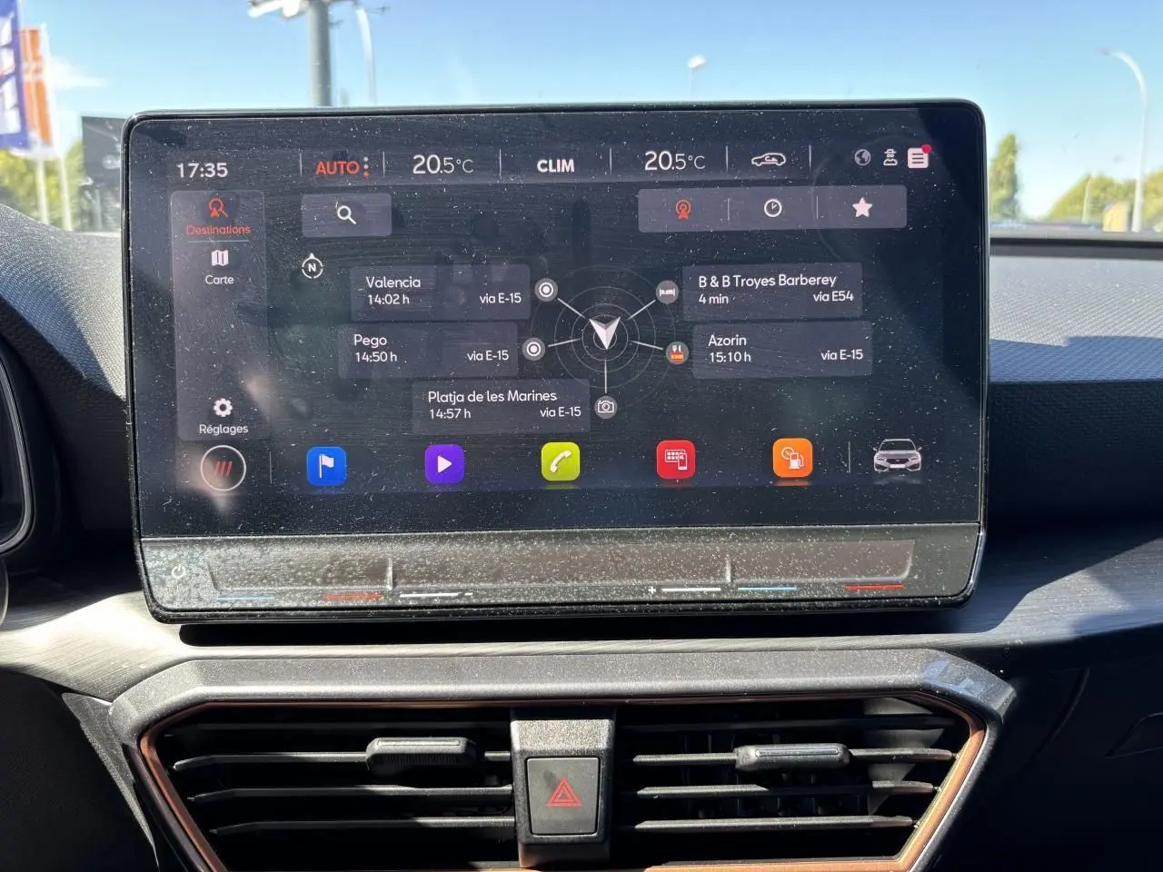 Écran tactile central du tableau de bord du CUPRA Leon Sportstourer blanc Nevada, affichant le système de navigation.