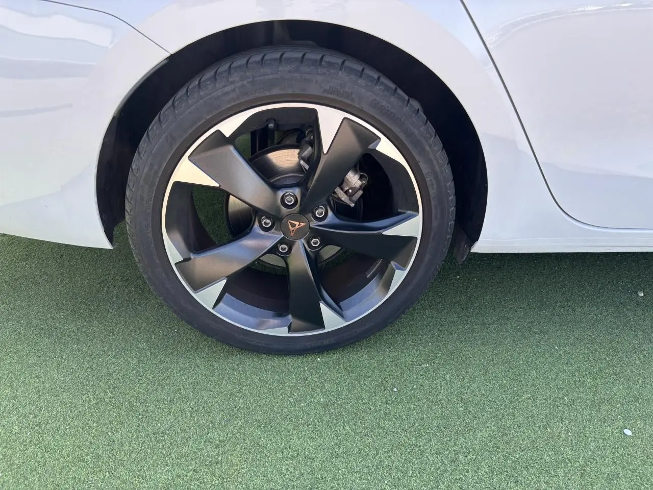 Gros plan sur la roue arrière droite d'une CUPRA Leon Sportstourer blanche avec jante alliage 18 pouces bicolore.