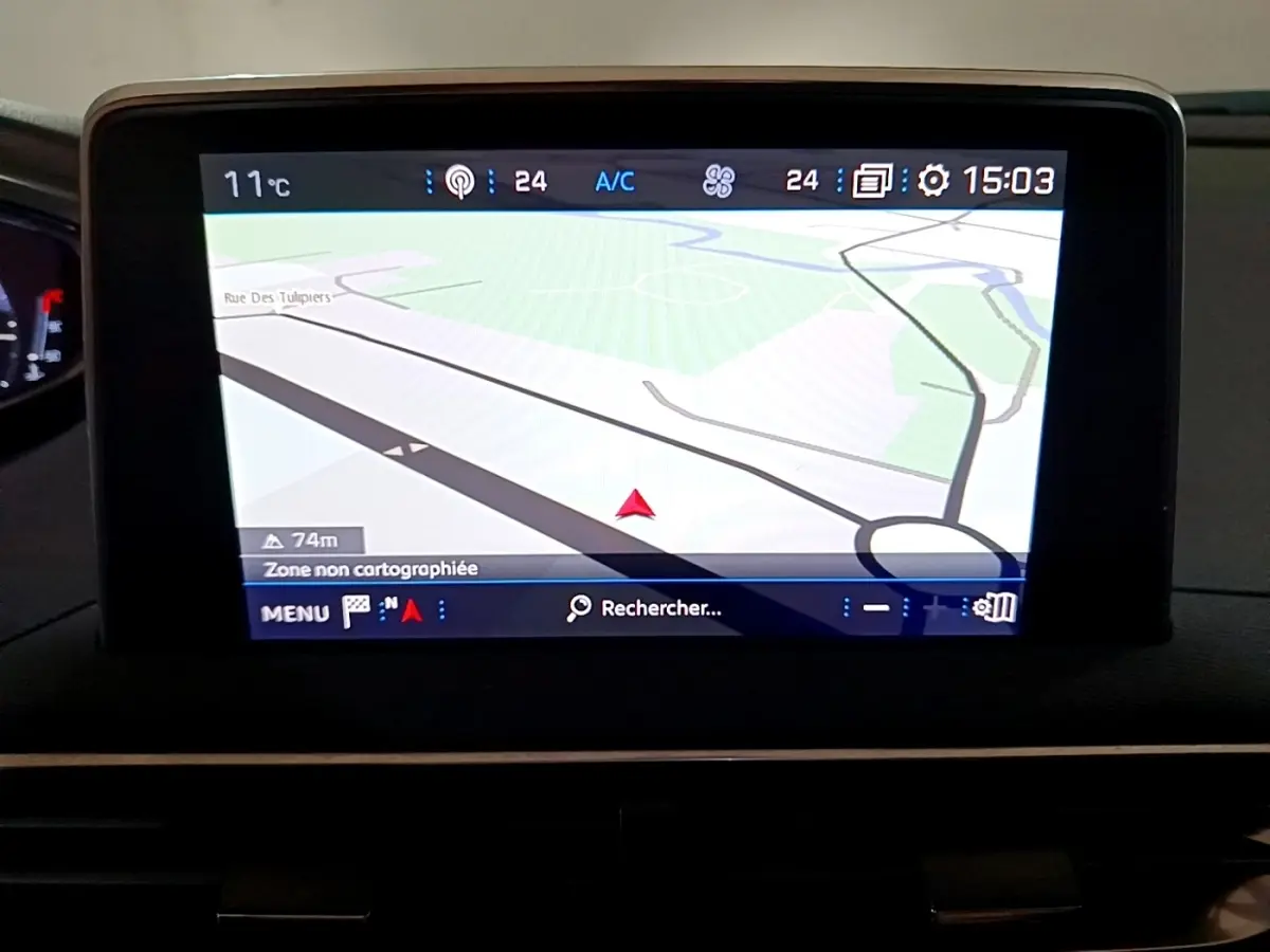 Écran tactile central du tableau de bord du Peugeot 5008 bleu, affichant la navigation GPS en vue 3D.